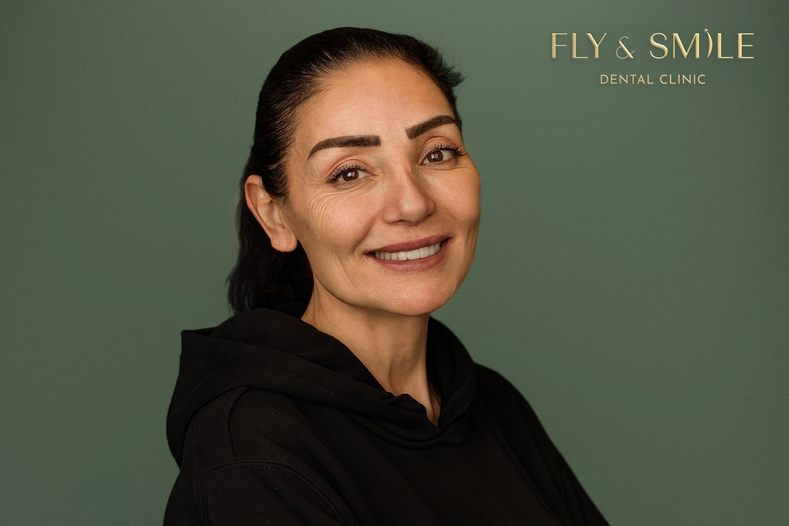 מטופלת של Fly & Smile מחייכת בסטודיו של המרפאה