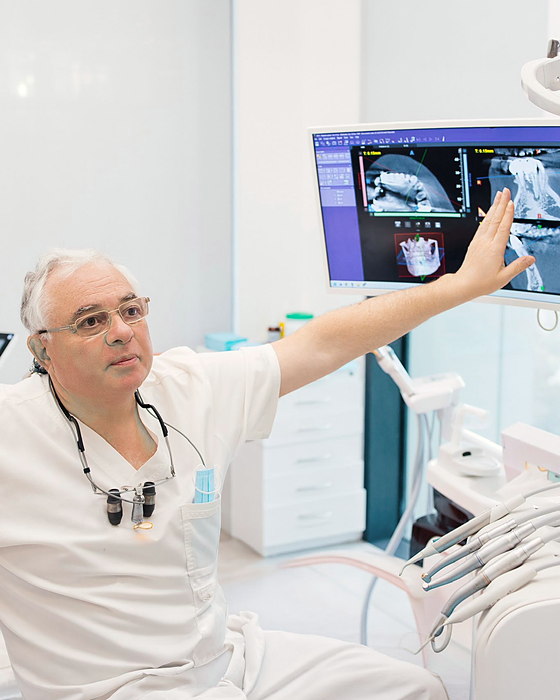 ד"ר דמיטרי לנצט מצביע על סריקת CT במסך חדר הטיפולים