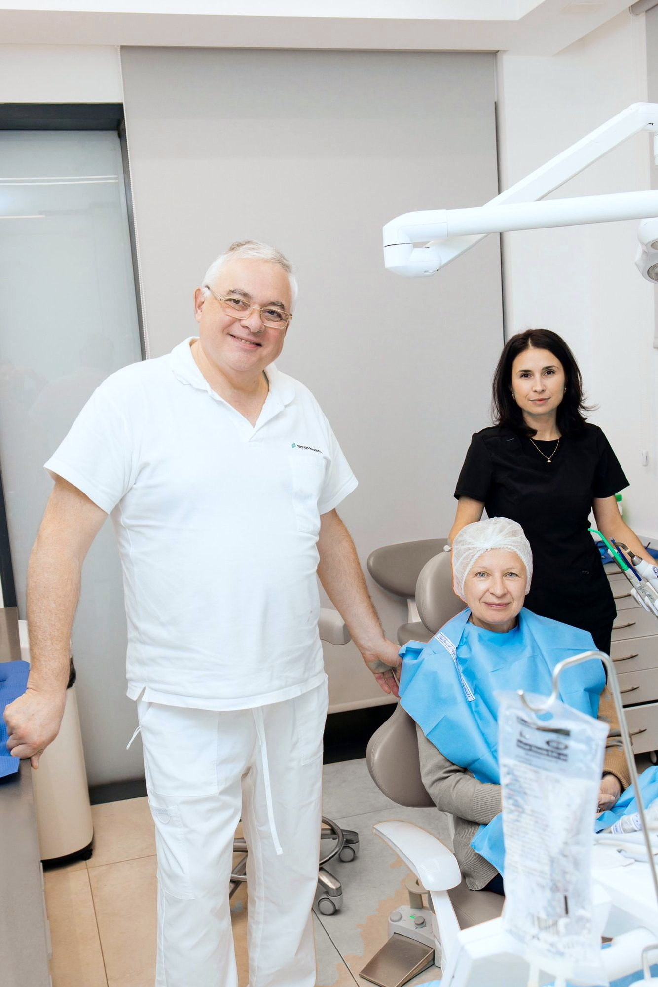 צוות הקליניקה לצד מטופלת בכיסא הטיפולים לקראת תחילת בדיקה ואבחון